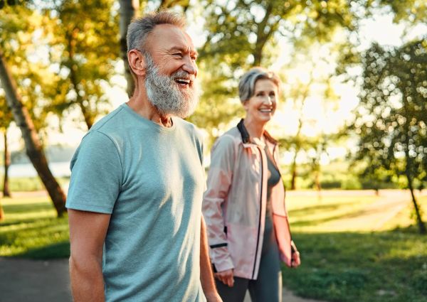 Couple in their 60s walking outdoors, planning for Medicare at 65